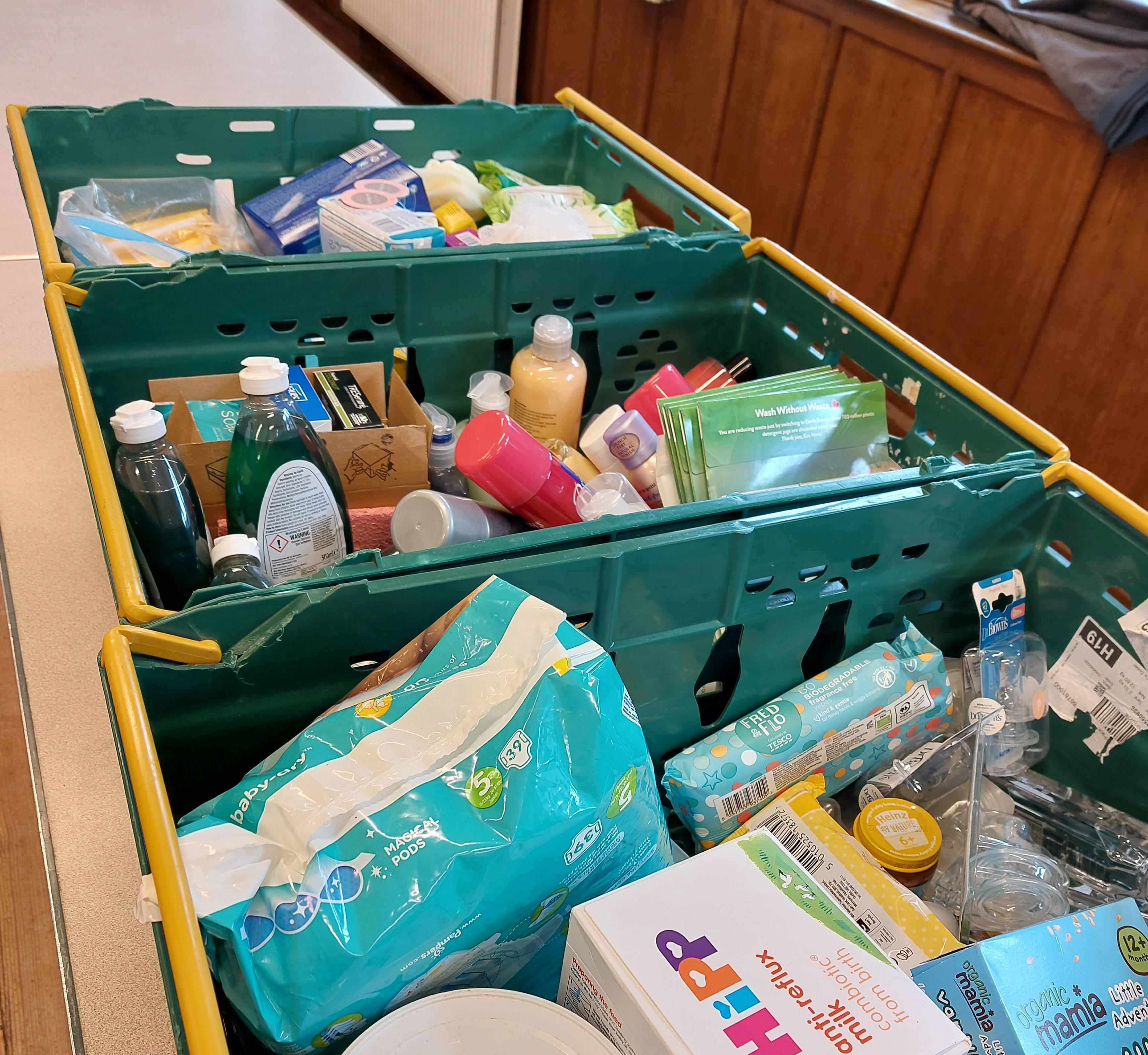 A green food basket full of items at a foodbank.