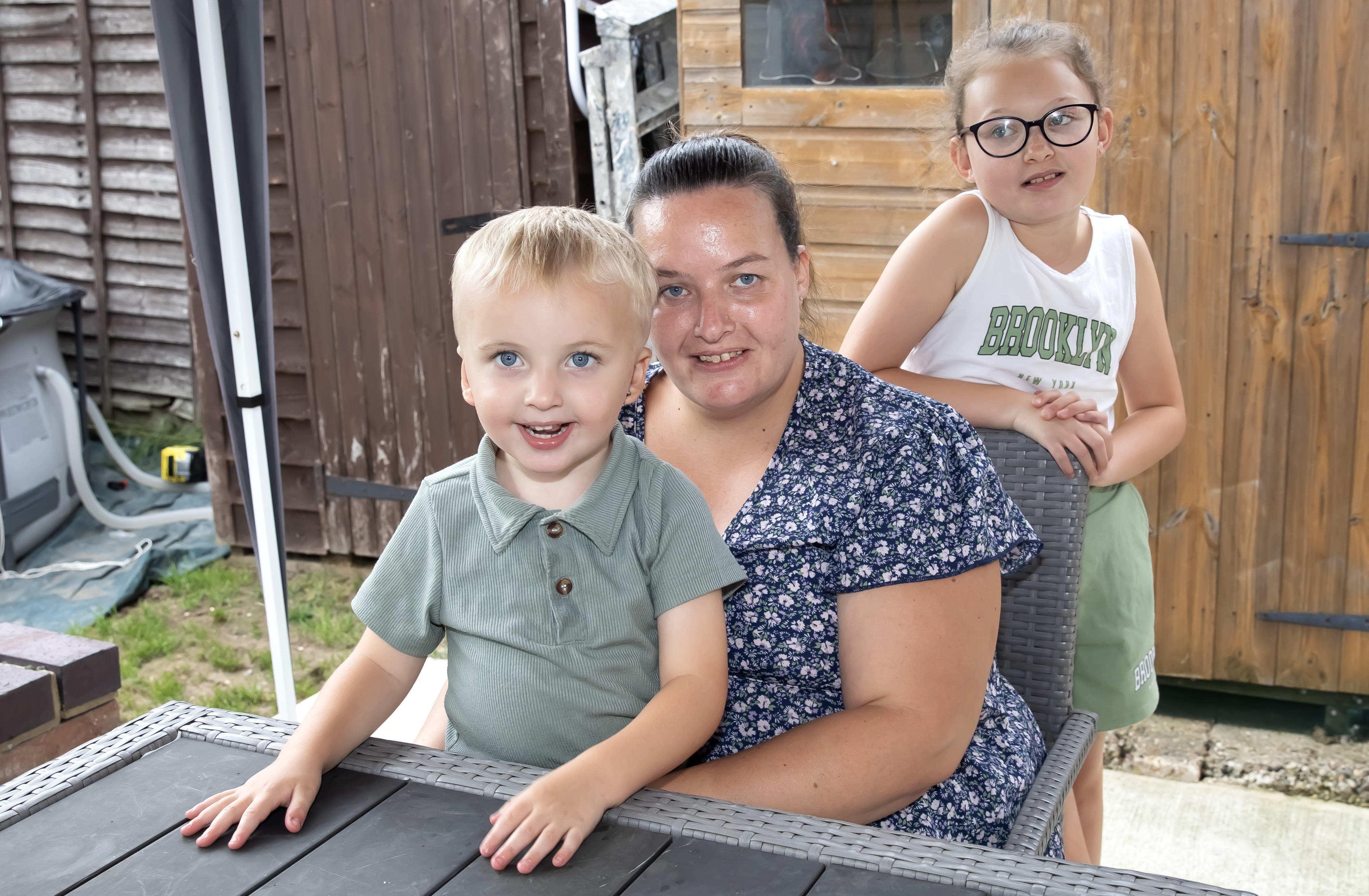 Eastlight resident Michaela Thomas and her two kids, smiling at a camera